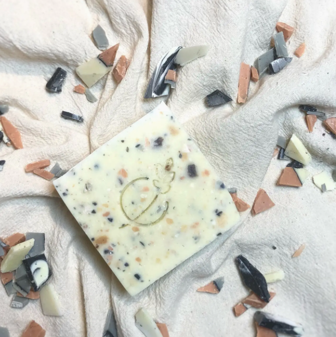 Decorative soap bar with colorful specks on a textured white surface