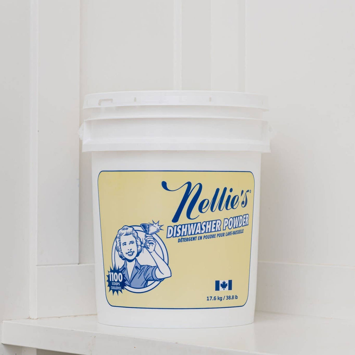 Bucket of Nellie's Dishwasher Powder on a white tiled wall background