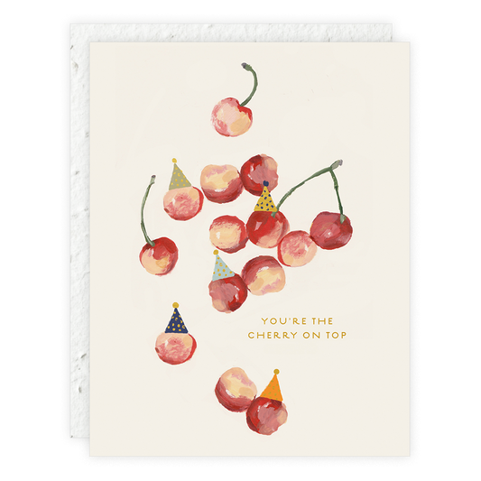 A greeting card with an illustration of cherries with birthday candles on top, alongside a textual message that reads 'You're the cherry on top'.