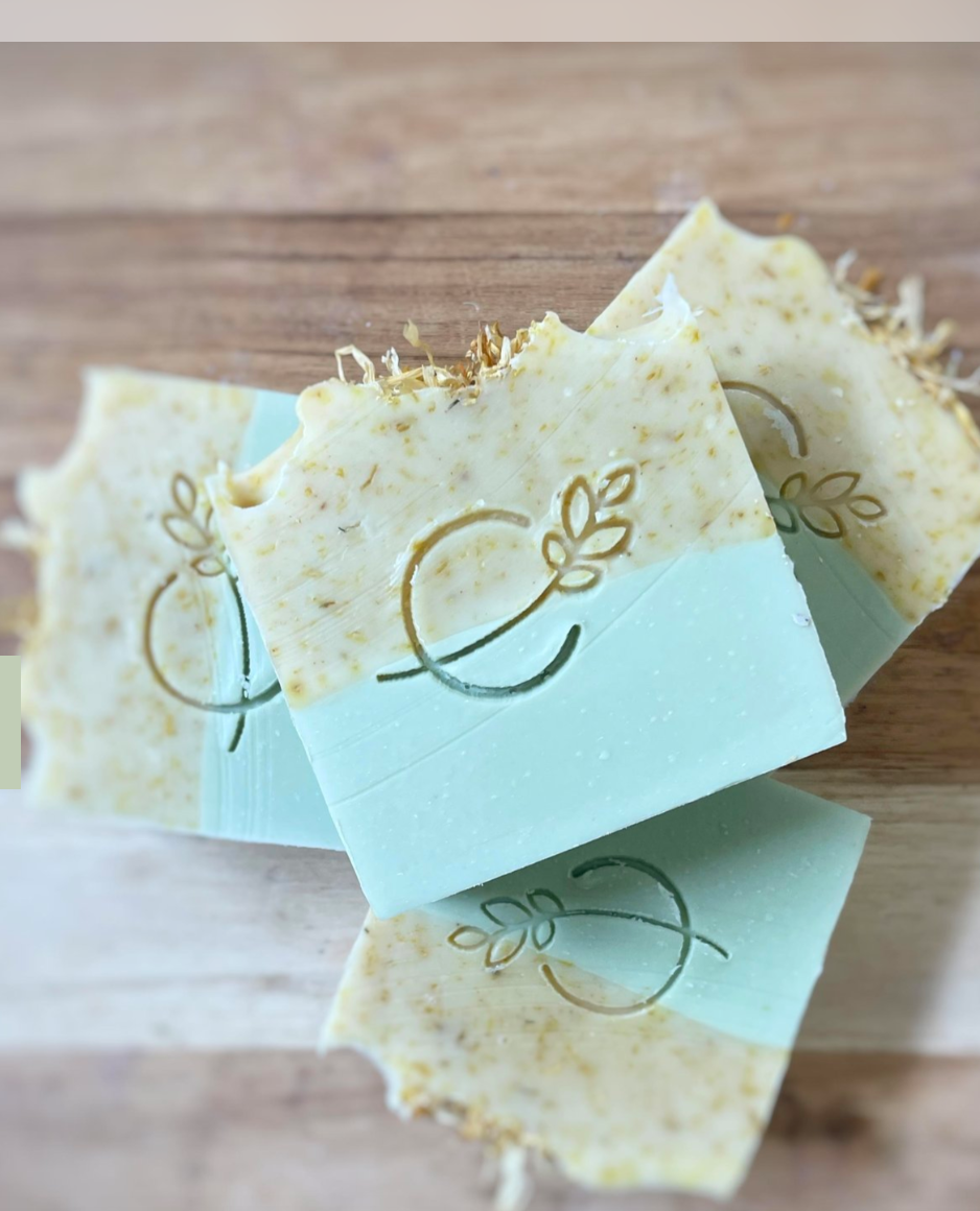 Square soap bars with a logo on a wooden surface