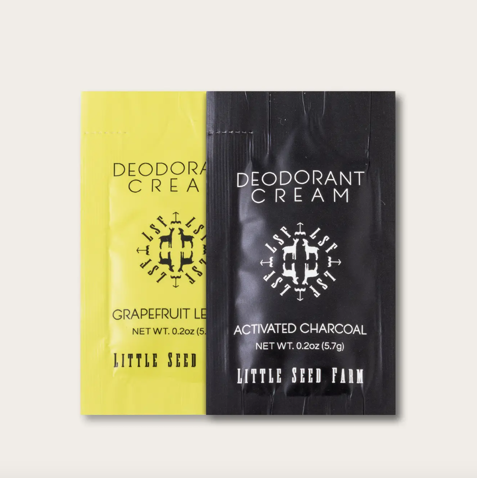 Two packets of Little Seed Farm deodorant cream, one yellow and one black, on a white background.