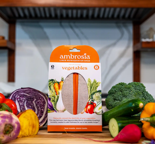 Packaging of Ambrosia Linen Refrigerator Bag for vegetables, displaying the product in a kitchen with vegetables.